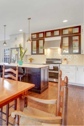 a large kitchen with wooden floors and white cabinets