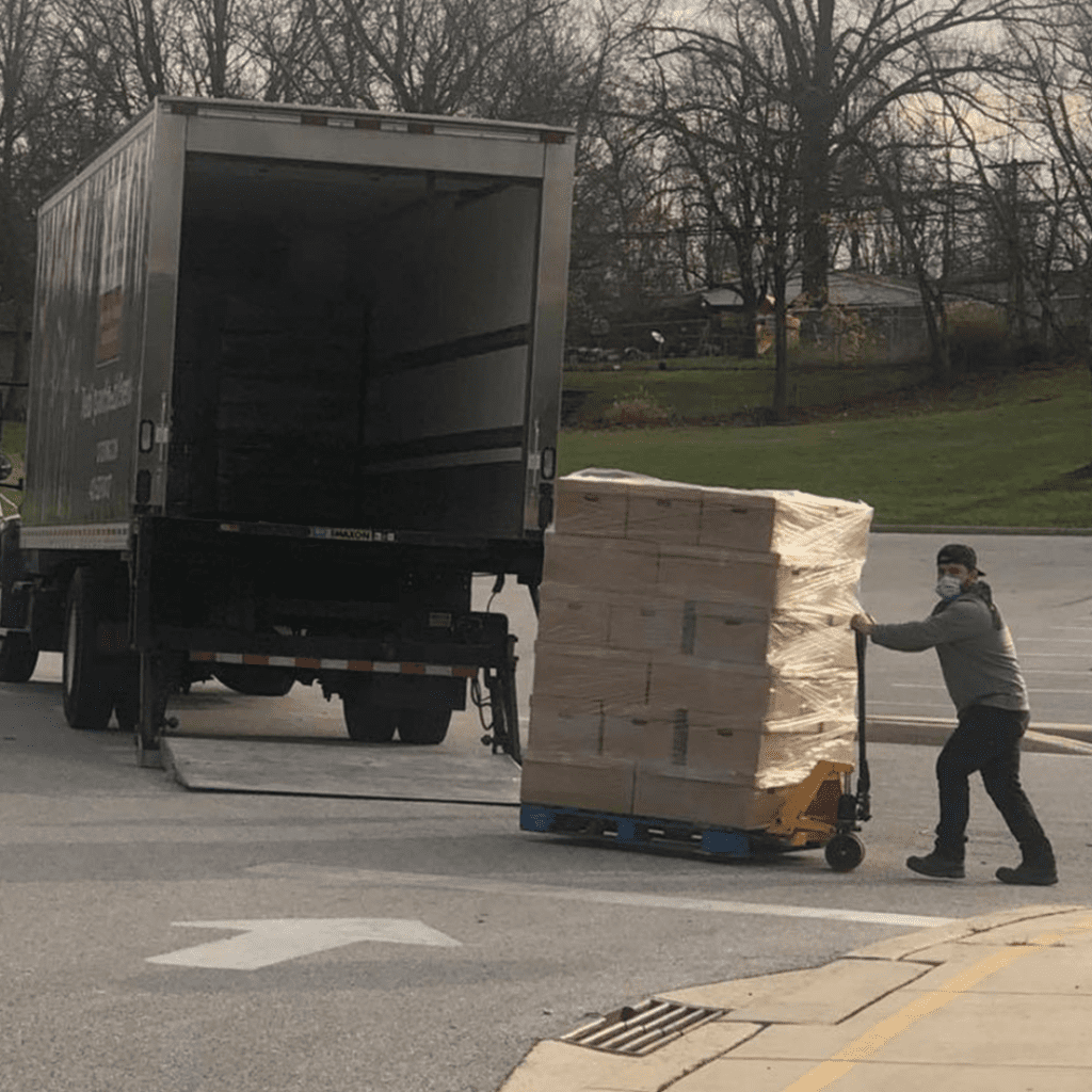 a man unloading boxes from the back of a truck