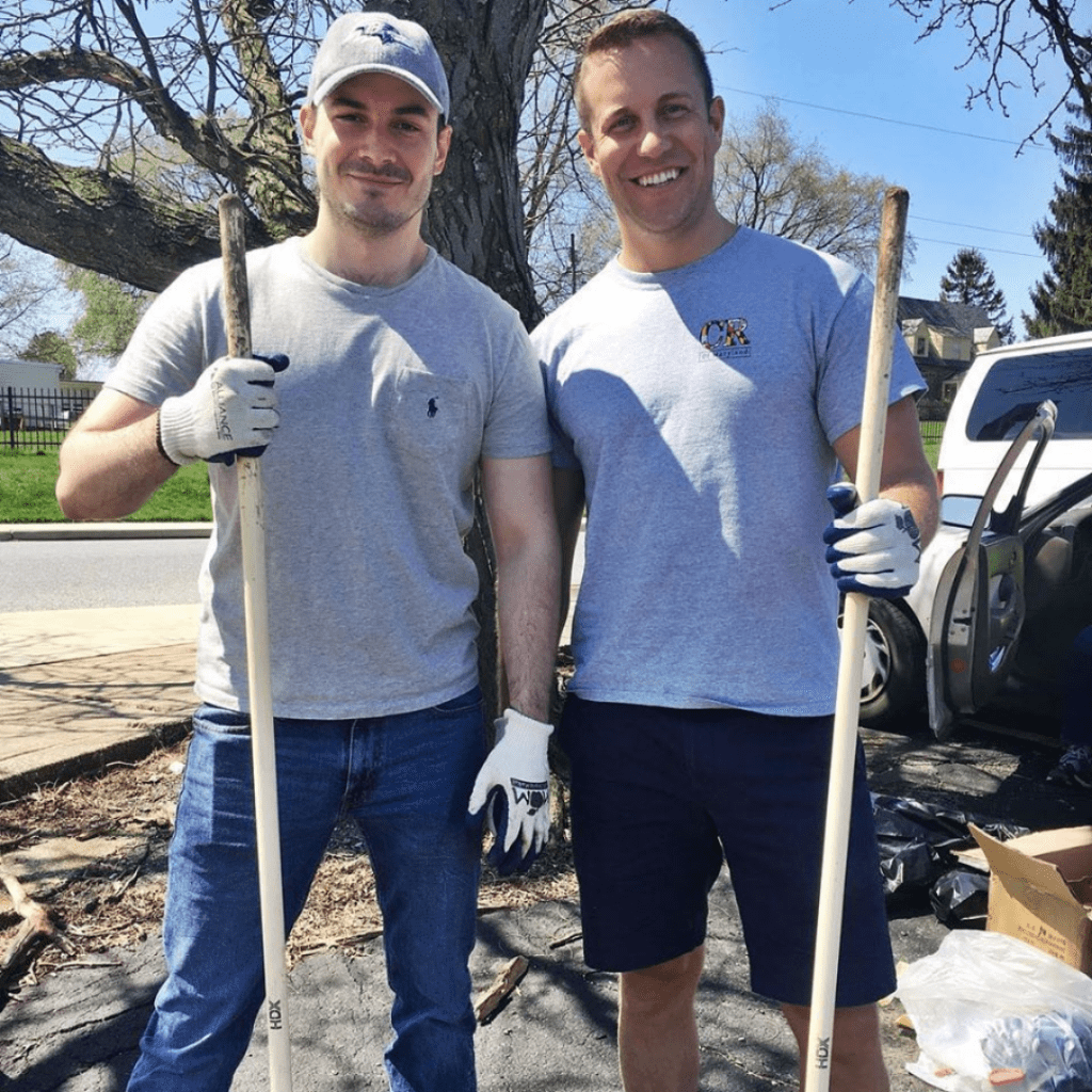 two men are holding shovels and standing next to each other