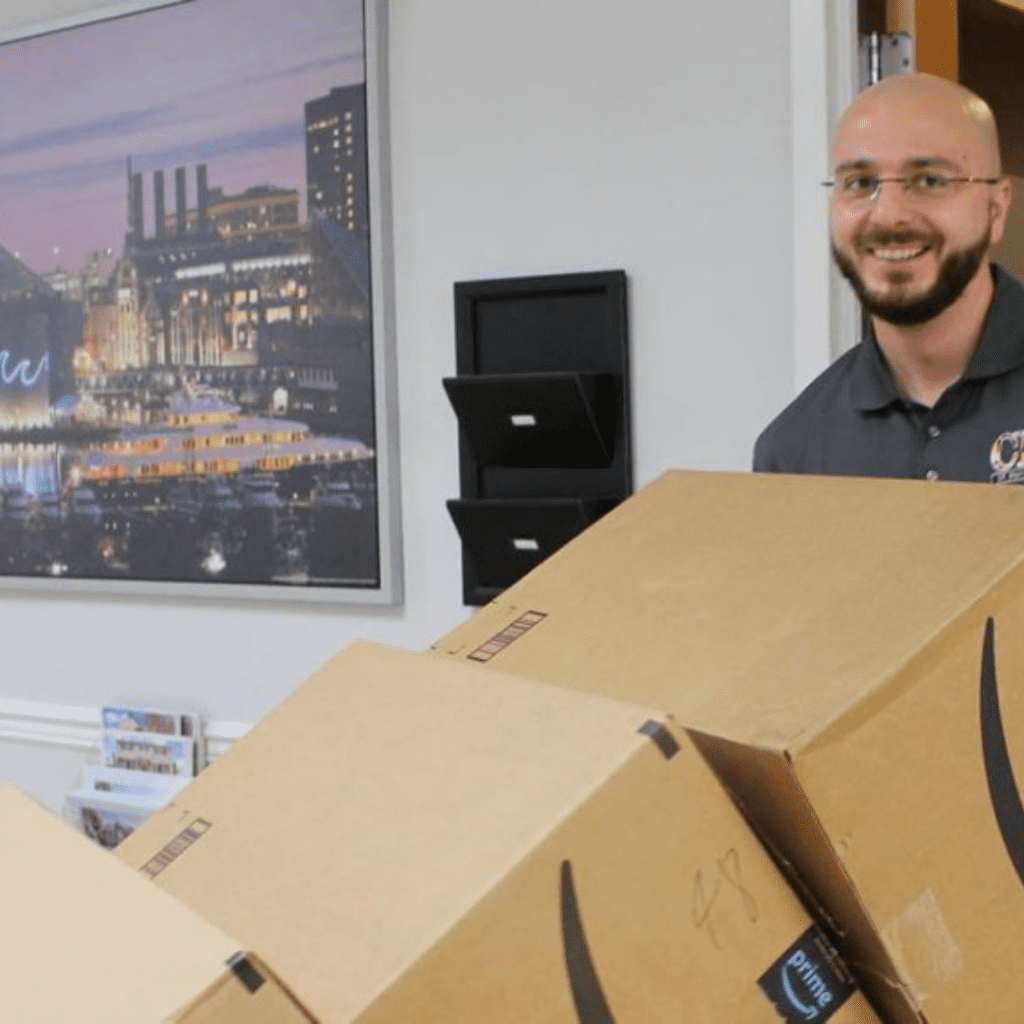 a man standing next to boxes in an office