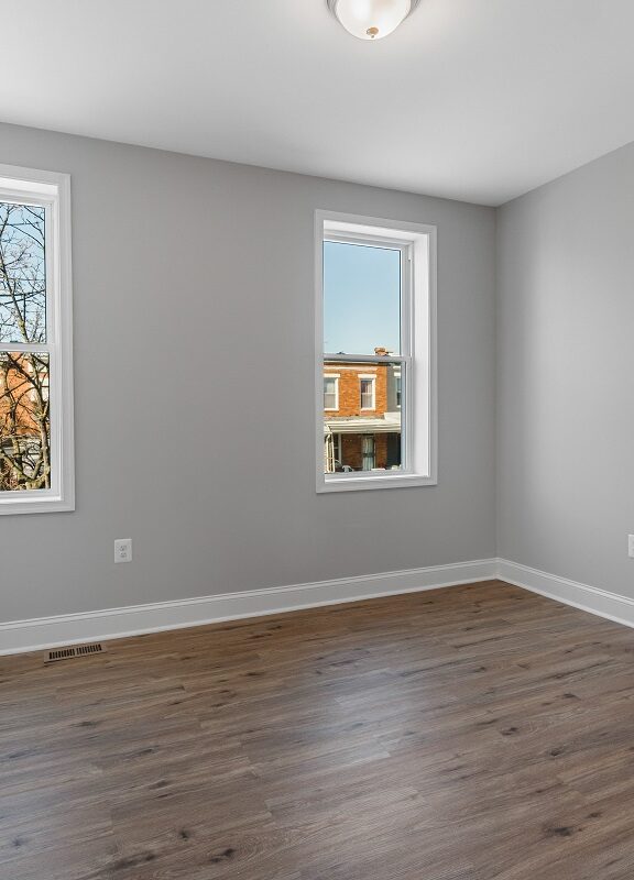 Picture of empty room with two windows and new floors.