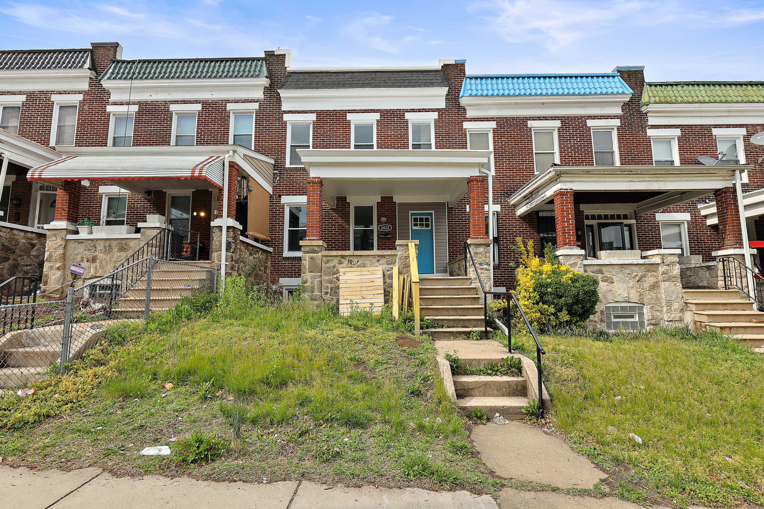 a row of brick townhouses with stairs leading up to the front door