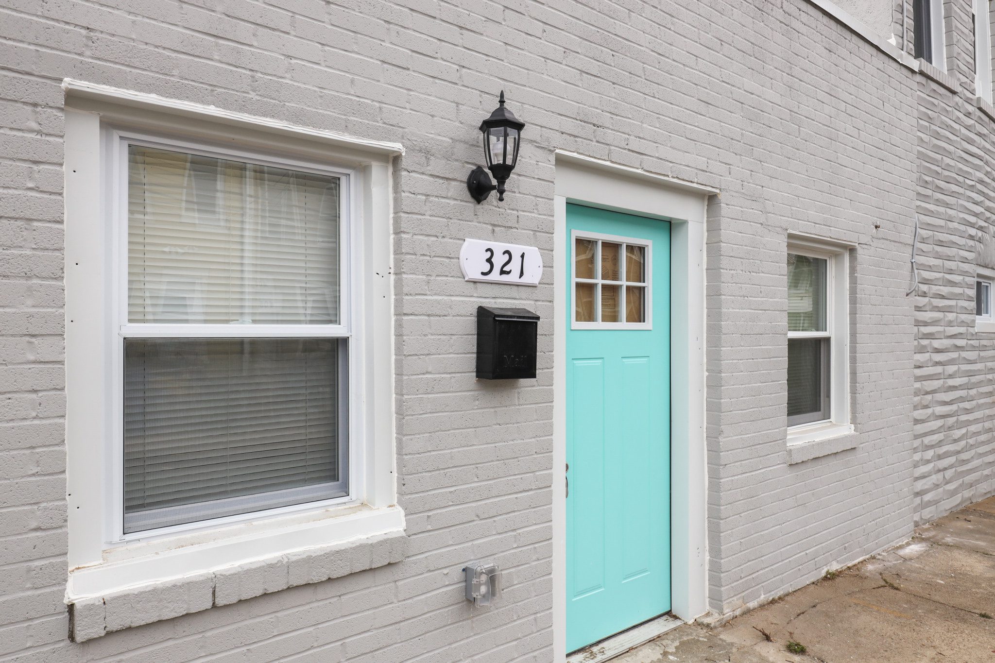 a blue door is on the side of a gray brick building
