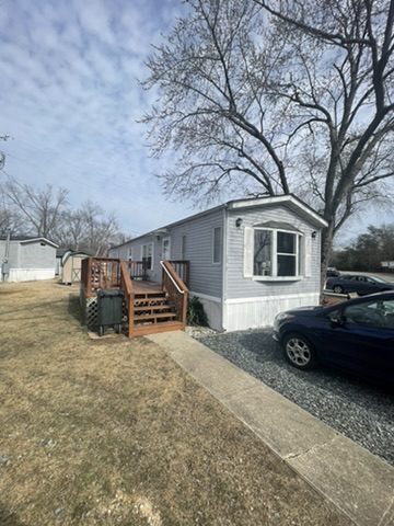 a mobile home with a car parked in front of it